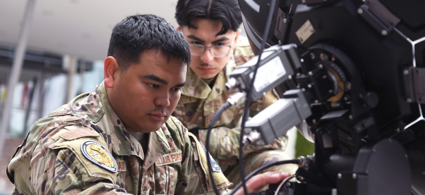 Air Force Staff Sgt. Javin Delgado, a electronic warfare specialist with the Hawaii Air National Guard’s 154th Wing, prepares to calibrate electronic warfare equipment as Senior Airman Osmar Mendoza, a space systems operator with the California Air National Guard's 216th Electromagnetic Warfare Squadron, looks on during Vulcan Guard Bolt 6, Ramstein Air Base, Germany, March 27, 2024.