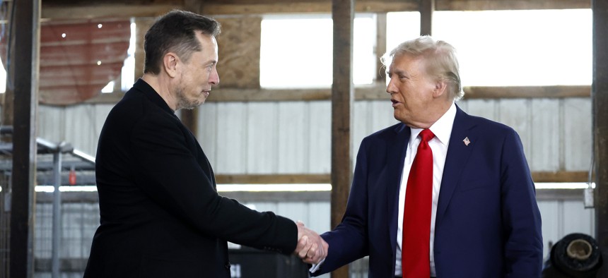 BUTLER, PENNSYLVANIA - OCTOBER 05: Elon Musk (L) shakes hands with Republican presidential nominee, former President Donald Trump back stage during a campaign rally at the Butler Farm Show grounds on October 05, 2024 in Butler, Pennsylvania.